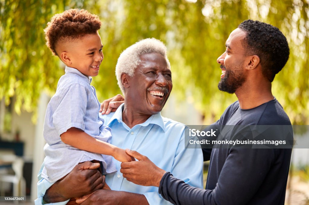 Smiling Multi-Generation Male Family At Home In Garden Together Father Stock Photo