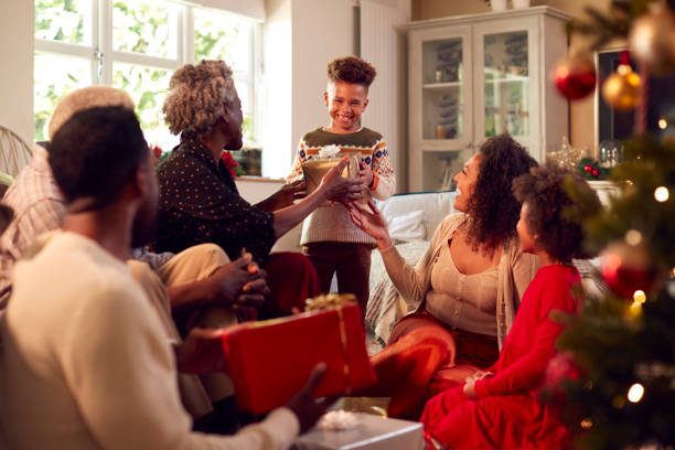 wielopokoleniowa rodzina wymieniająca i otwierająca prezenty wokół choinki w domu - grandmother giving gift child zdjęcia i obrazy z banku zdjęć