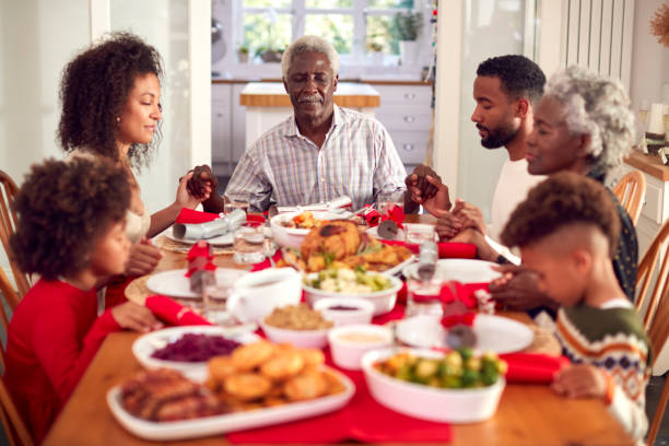 istock Multi Generation Family Hold Hands Around Table At Home Saying Grace Before Eating Christmas Meal 1336674088