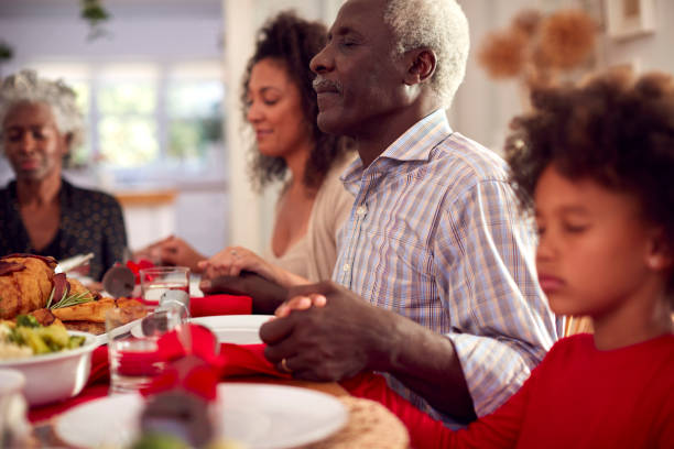 istock Multi Generation Family Hold Hands Around Table At Home Saying Grace Before Eating Christmas Meal 1336674202