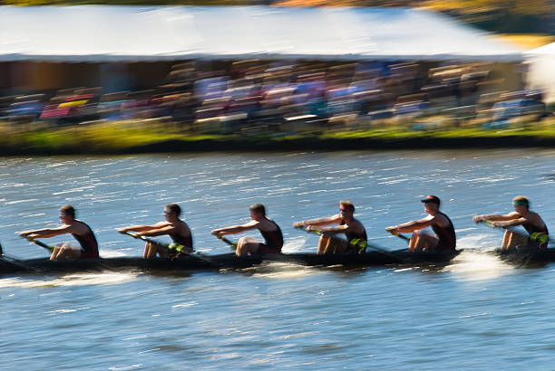 Teamwork Speeding rowing boat with motion blur to accent speed. rowing stock pictures, royalty-free photos & images