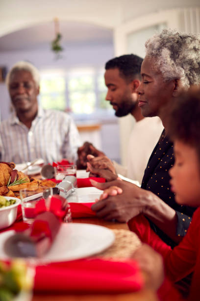 istock Multi Generation Family Hold Hands Around Table At Home Saying Grace Before Eating Christmas Meal 1336680834