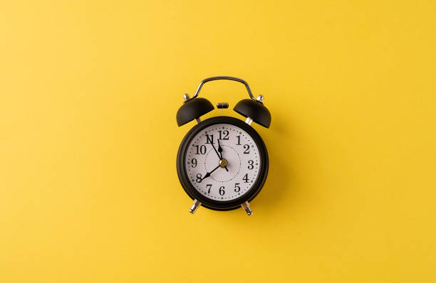 istock White retro alarm clock isolated on yellow background with copy space 1336682326
