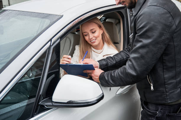 istock Woman inside her new car entering into purchase agreement. 1336682693