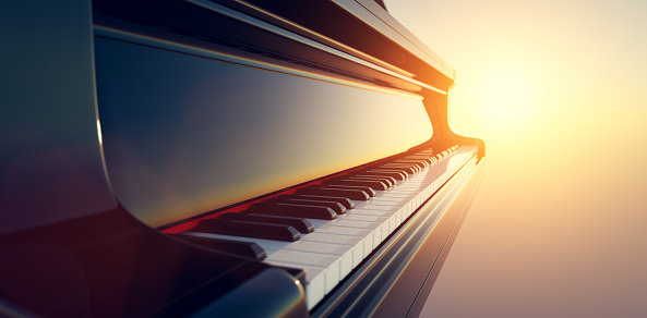 Grand piano keyboard on sunset sky background. Music and entertainment