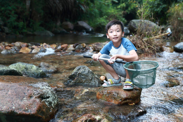 istock Boys fishing in stream 1336684627