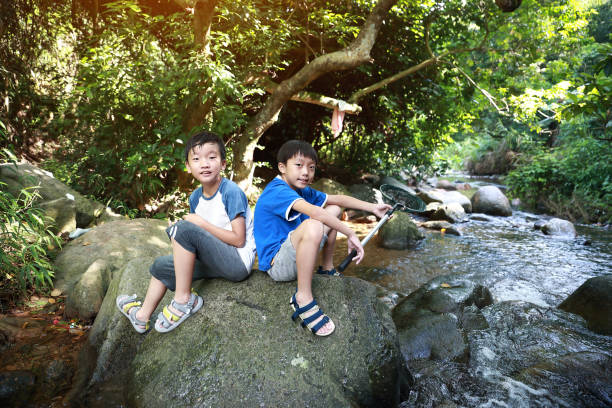 istock Boys fishing in stream 1336684844