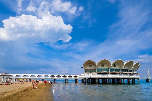 People enjoying a sunny day on the beach of Lignano Sabbiadoro, a summer tourist spot on the Adriatic see coast.