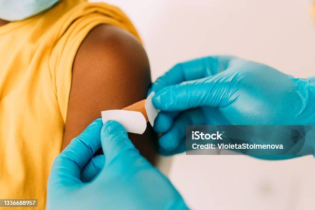 Doctor Putting A Bandage After Covid19 Vaccination Stock Photo - Download Image Now