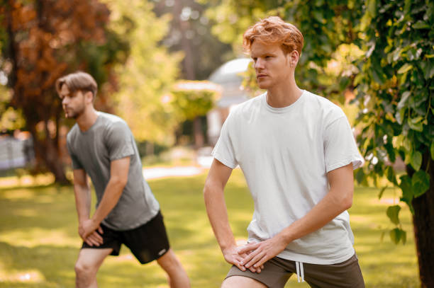 istock Guys in sportswear doing exercises in nature 1336698248