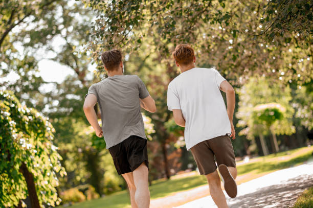 istock Guys running in park with backs to camera 1336698260