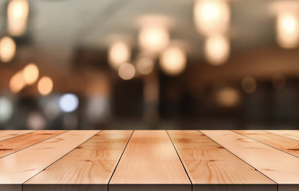 istock Empty wooden table top with lights bokeh on blur restaurant background. 1336699793