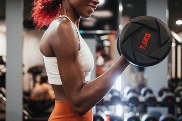istock Anonymous Sportswoman Using Dumbbells for her Workout Session at the Gym 1336700429