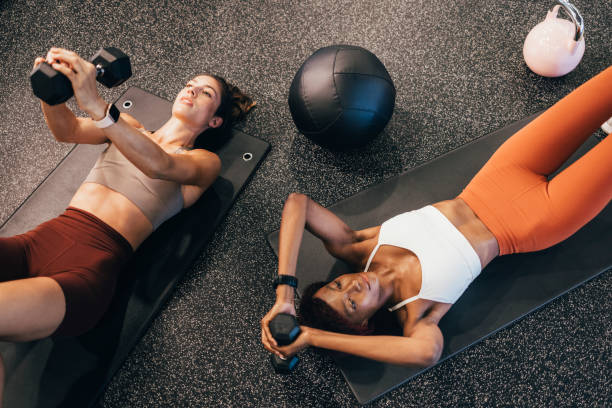 istock Two Beautiful Sportswomen Exercising on a Mat at the Gym 1336700466