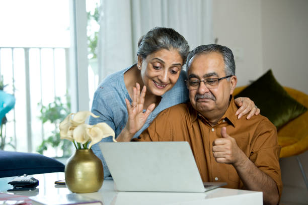 istock Old couple having fun using laptop at home 1336702912
