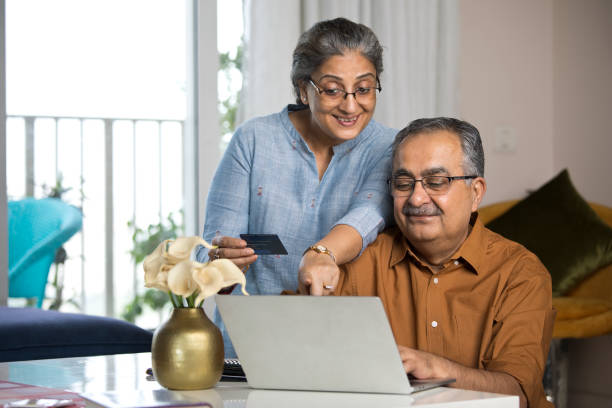 istock Old couple using laptop and credit card at home 1336702995