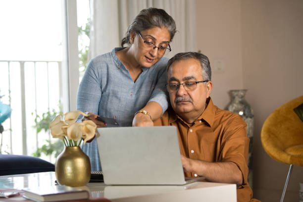 istock Old couple using laptop and credit card at home 1336703061