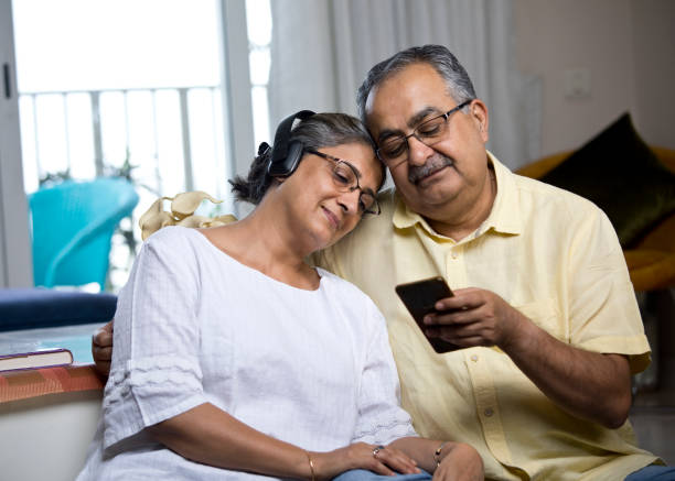 istock Old couple enjoying music using mobile phone and headphones 1336707327