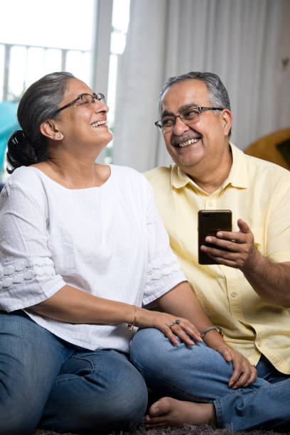 istock Old couple enjoying using mobile phone at home 1336708156