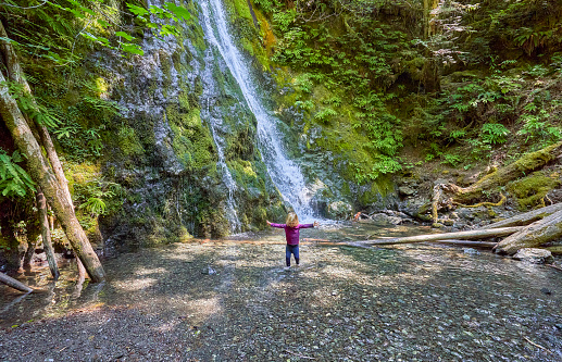 Toddler girl playing in Madison Creek Falls in the beautiful Olympic National Park in Western Washington State USA.
