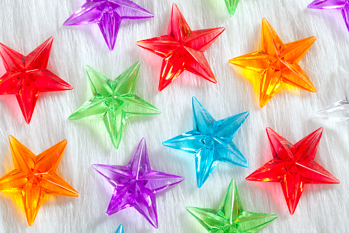 christmas colorful glass stars over white fur background as snow