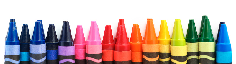 Row of crayons in a rainbow of colors isolated on white