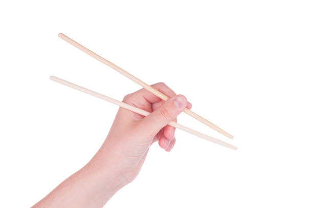 istock Hand holding chopsticks on white background 1336711857