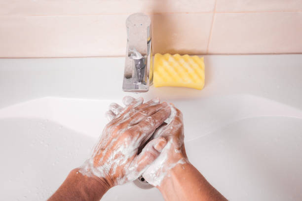 istock Man washing hands with soap under faucet in bathroom 1336712026