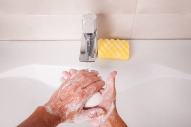 istock Man washing hands with soap under faucet in bathroom 1336712056