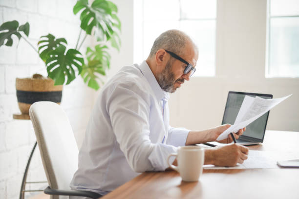 istock mature adult man working from office ( with laptop,paperwork) 1336713084