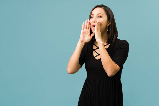 istock Hispanic woman trying to get someone's attention 1336713161