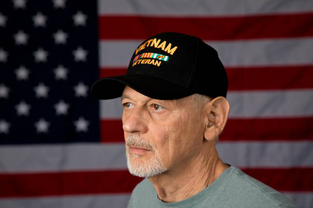 istock Vietnam Veteran looking away from camera, American Flag background 1336714090
