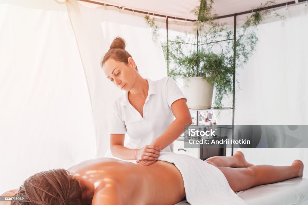 Femme masseur faisant un massage du dos - Photo de Masser libre de droits Femme masseur faisant un massage du dos - Photo de Masser libre de droits