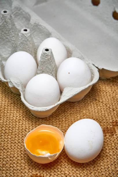 istock Fresh raw chicken eggs in a cardboard box on a burlap background. 1336718668