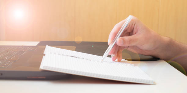 istock Businessman hands with pen writing notebook on office desk table close up. Business concept. 1336720403