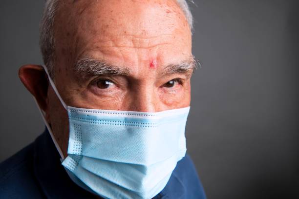 istock senior man wearing protective face mask looking at the camera 1336721682