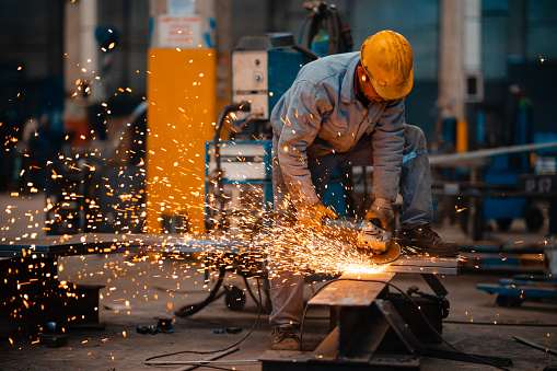 Worker welding steel in company.