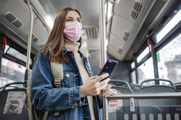 istock Woman with a protective face mask is using mobile phone in public transport 1336724795