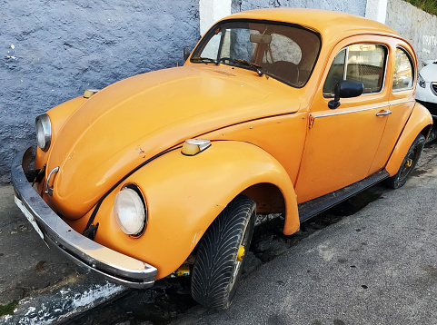 June 9, 2021. São Paulo, Brazil. An old Volkswagen Beetle parked on the sidewalk in a narrow street in São Paulo.