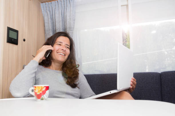 istock Middle-aged attractive spanish woman teleworking and communicating from her mobile office while on vacation at a campsite 1336726737