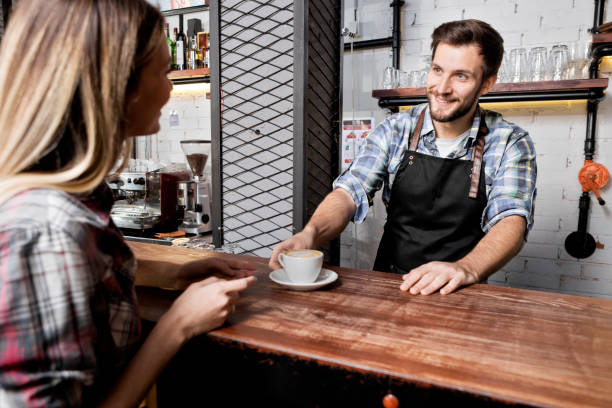 istock Bartender offering coffee to a young woman 1336729976