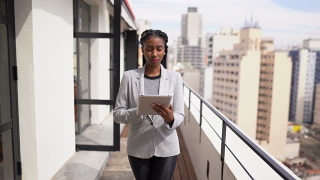 Young woman contemplating while using digital tablet on apartment's balcony