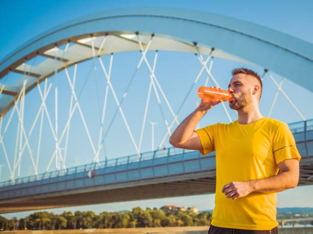 istock man wearing yellow drinking water during workout 1336730782