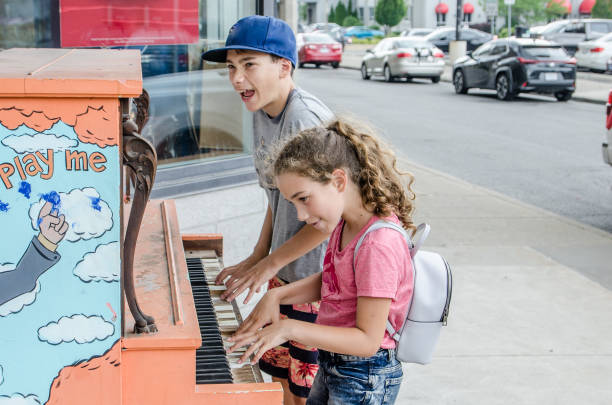 istock Two kids playing piano on the street 1336733188