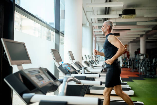 istock Mature athlete running on treadmill while exercising in a gym. 1336733623
