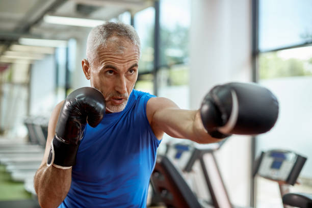 istock Mature man exercise boxing while working out in a gym. 1336734326