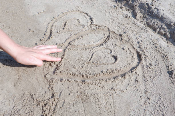istock On the sand there is an image of two hearts. 1336734439
