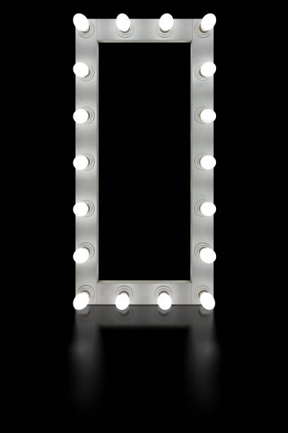 istock Vintage white mirror frame with glowing lamps, isolated on black background. Make-up mirror with built-in lamps. Professional luminous mirror with reflection. 1336734532