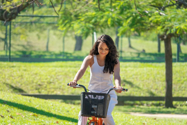 istock Young woman riding a bicycle in the park 1336734761
