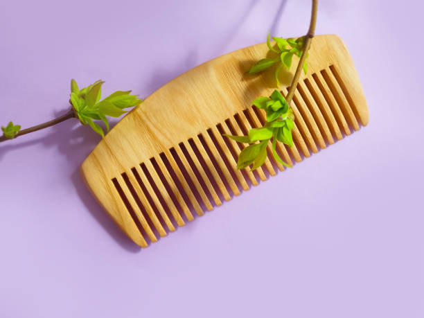 istock comb wooden green leaves on colored background 1336734803